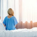 Woman Sitting on Edge of Bed in Hospital, Worried About IVC Filter